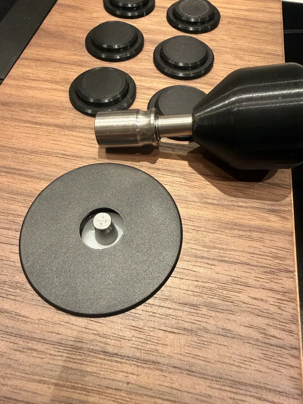 The stick's top lifted off, next to the buttons in the walnut